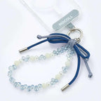 MOCOLL liquid ambar phone charm with blue beads and decorative bow attached to clear phone case